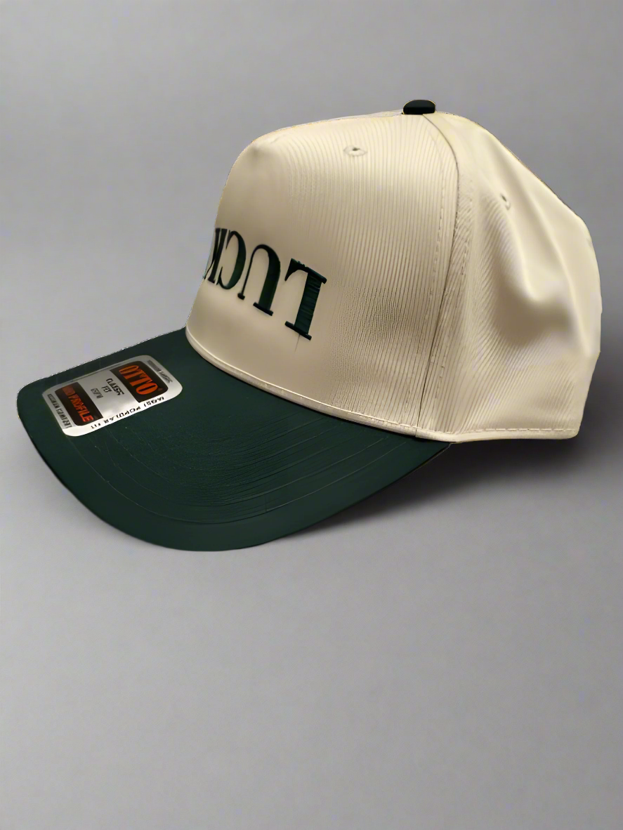 Cream and green snapback hat with upside-down 'LUCKY' embroidered in green, featuring a curved bill and adjustable snapback closure.